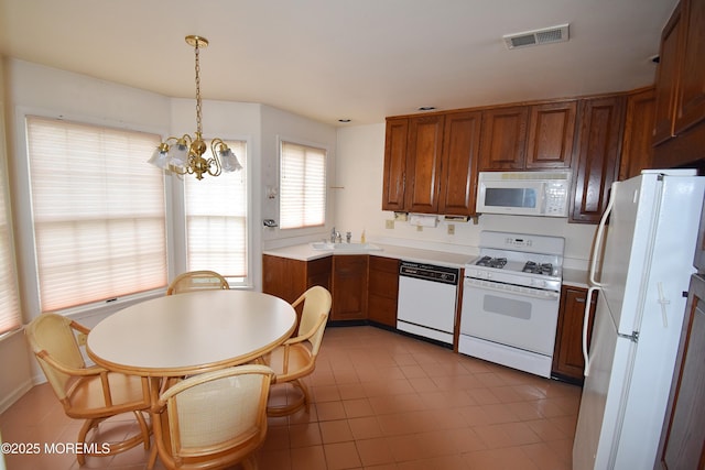 126 Cardigan Ct, Manchester, NJ 08759 - kitchen featuring white appliances, brown cabinets, a sink, a chandelier, and light countertops