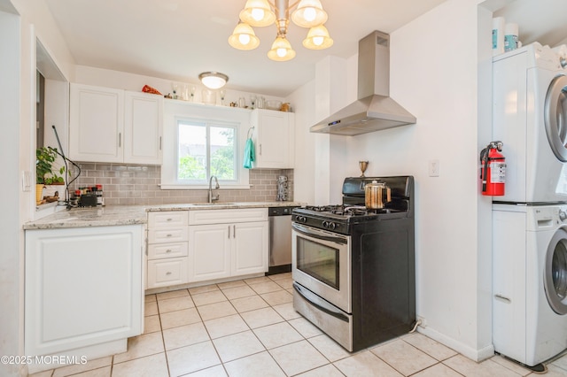 1118 Jeffrey St, Asbury Park, NJ 07712 - kitchen featuring appliances with stainless steel finishes, stacked washer and clothes dryer, wall chimney range hood, a sink, and light tile patterned flooring
