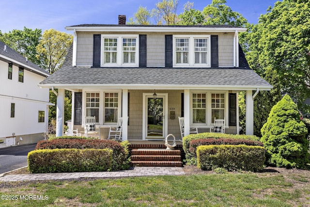 view of front of property with a porch, a shingled roof, and a chimney