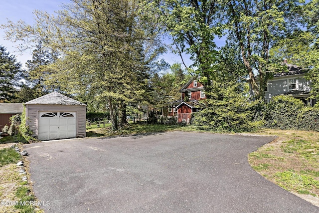 exterior space featuring driveway, an outbuilding, and a garage