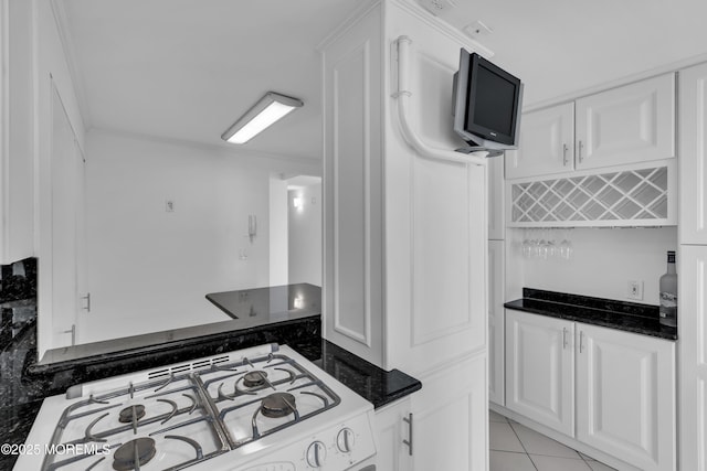 55 Ocean Ave Unit 3L, Monmouth Beach, NJ 07750 - kitchen with white gas stove, white cabinets, dark stone countertops, and light tile patterned flooring