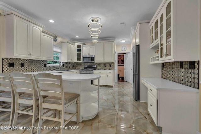 3688 Ridgeway Rd, Manchester, NJ 08759 - kitchen featuring appliances with stainless steel finishes, a kitchen bar, decorative backsplash, light countertops, and light marble finish flooring