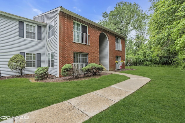 view of front of house featuring a front yard and brick siding