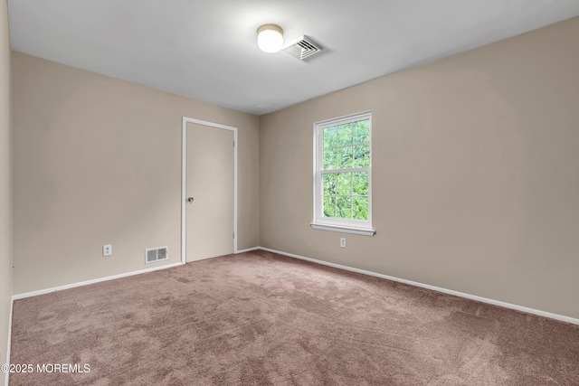 unfurnished room with carpet flooring and baseboards