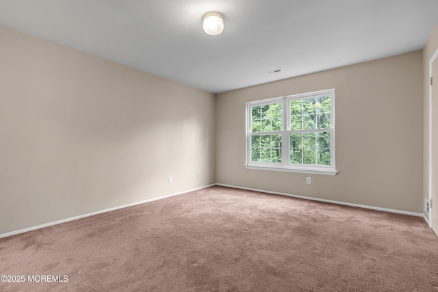 carpeted spare room with baseboards
