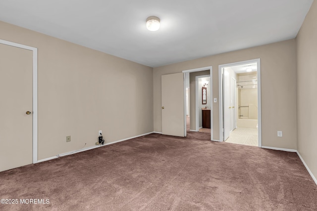 unfurnished bedroom with carpet, connected bathroom, and baseboards