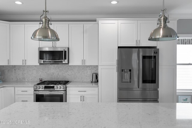 kitchen featuring stainless steel appliances, light stone counters, white cabinets, hanging light fixtures, and backsplash