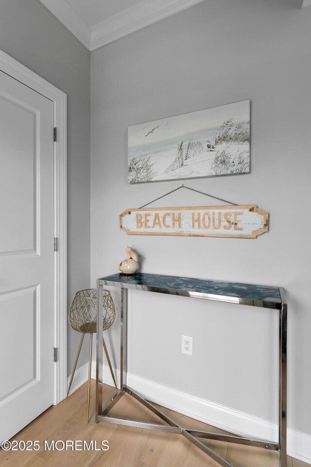detailed view of crown molding, wood finished floors, and baseboards