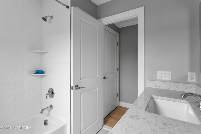 bathroom with a sink, shower / bath combination, and wood finished floors