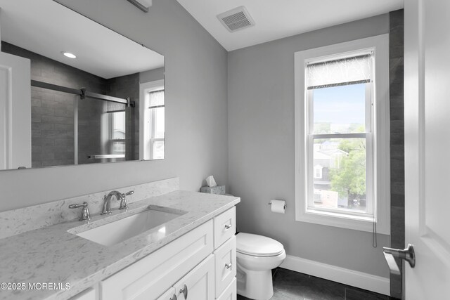 full bathroom featuring a shower stall, vanity, toilet, baseboards, and tile patterned floors
