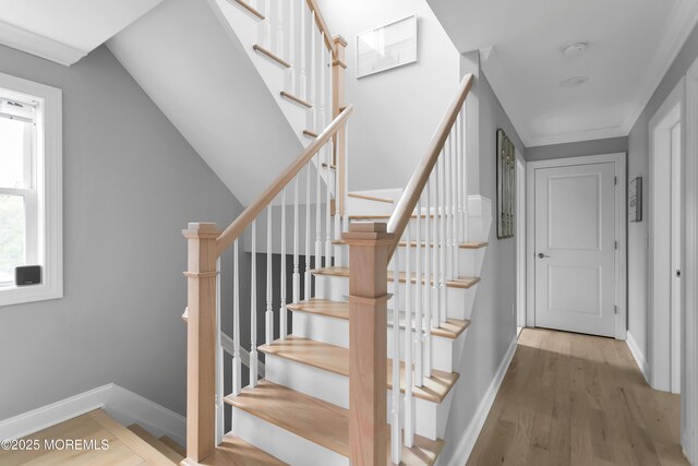 stairs featuring wood finished floors and baseboards