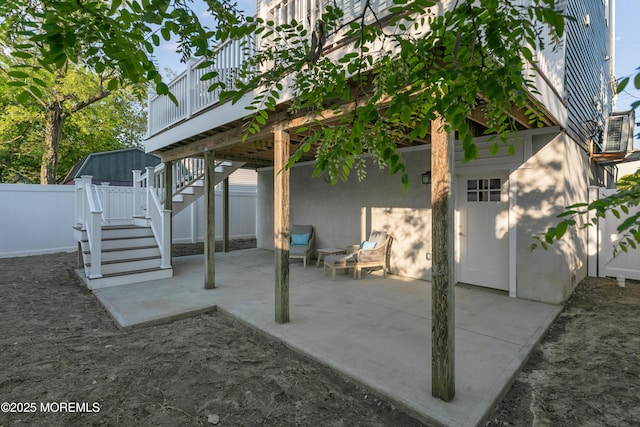 view of patio / terrace featuring stairs, a wooden deck, and fence