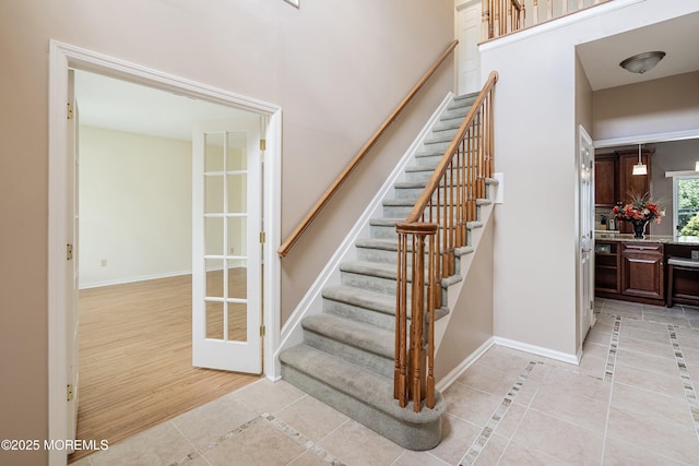 stairway featuring tile patterned flooring and baseboards