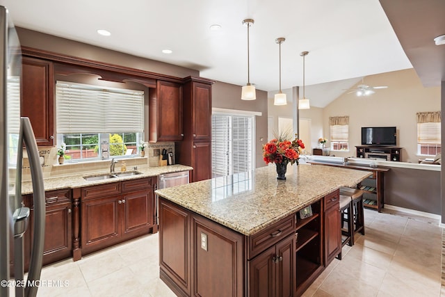 kitchen with a sink, appliances with stainless steel finishes, decorative backsplash, a center island, and light tile patterned floors
