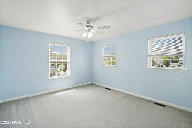 carpeted spare room with baseboards and a ceiling fan