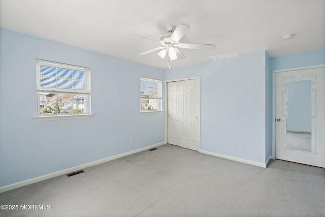 unfurnished bedroom featuring carpet, baseboards, a closet, and ceiling fan