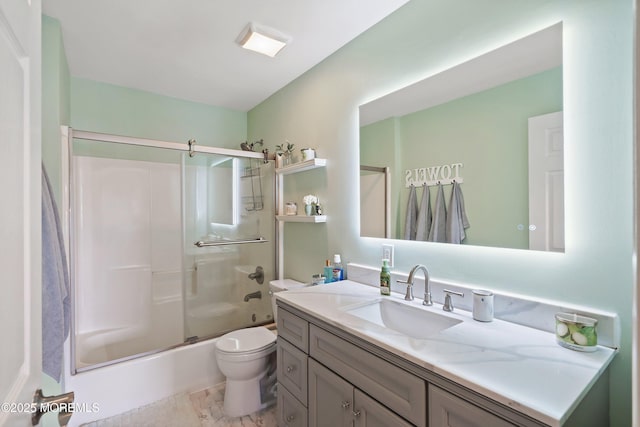 bathroom featuring toilet, vanity, and combined bath / shower with glass door