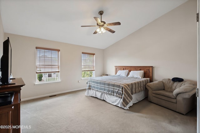bedroom featuring light colored carpet, vaulted ceiling, baseboards, and a ceiling fan