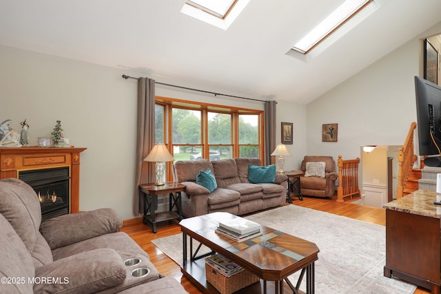 2 Nassau Pl, Middletown, NJ 07748 - living area with a skylight, light wood finished floors, a warm lit fireplace, and high vaulted ceiling