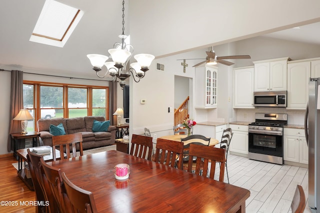 2 Nassau Pl, Middletown, NJ 07748 - dining space featuring vaulted ceiling, light wood finished floors, a ceiling fan, a chandelier, and stairs