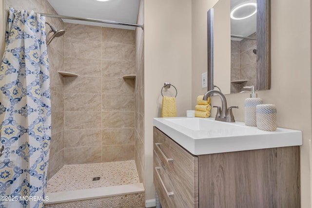 bathroom featuring a tile shower and vanity