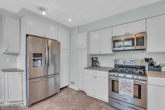kitchen featuring stainless steel appliances, white cabinets, light stone countertops, baseboards, and recessed lighting