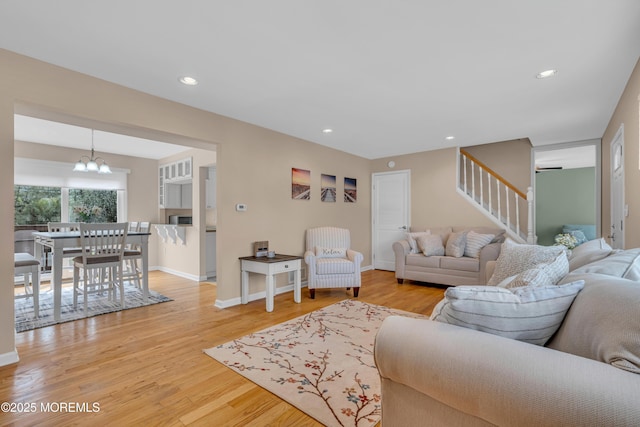 living room with stairway, light wood-style floors, a chandelier, baseboards, and recessed lighting