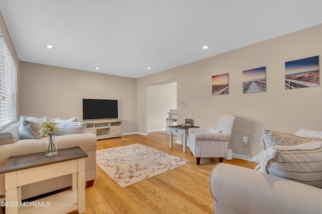 living room featuring light wood-type flooring, baseboards, and recessed lighting