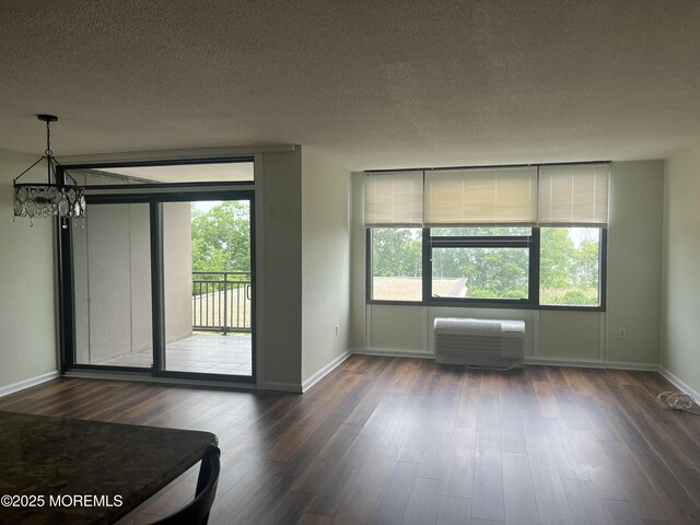 1 Scenic Dr Unit 207, Highlands, NJ 07732 - spare room featuring a chandelier, dark wood-style flooring, baseboards, a textured ceiling, and healthy amount of natural light