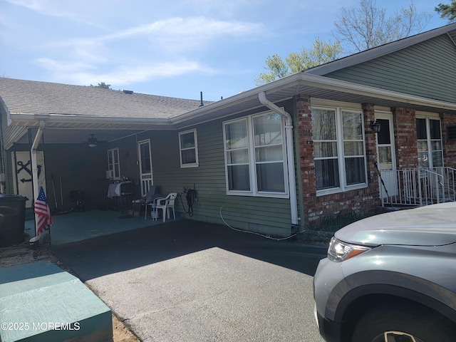 view of side of home featuring brick siding and ceiling fan