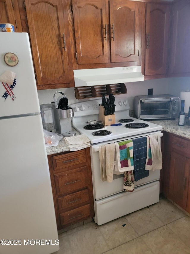 kitchen featuring a toaster, brown cabinetry, white appliances, under cabinet range hood, and light countertops