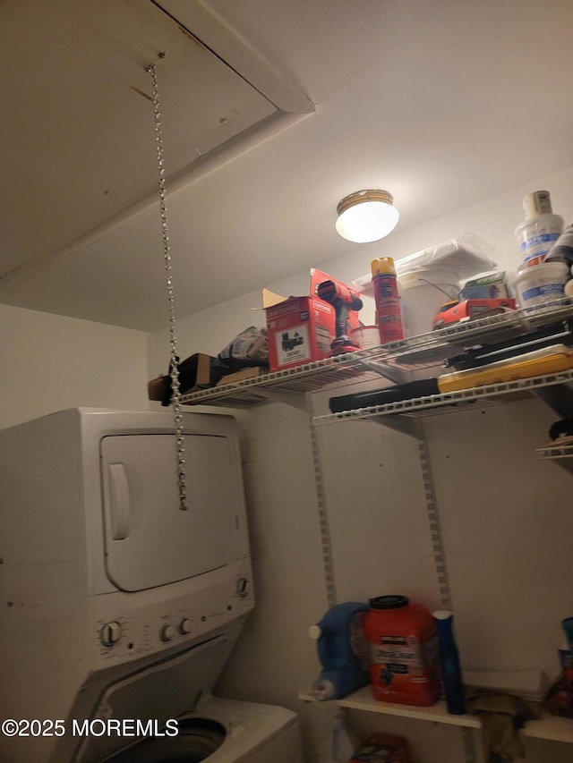 clothes washing area with stacked washer and dryer and laundry area