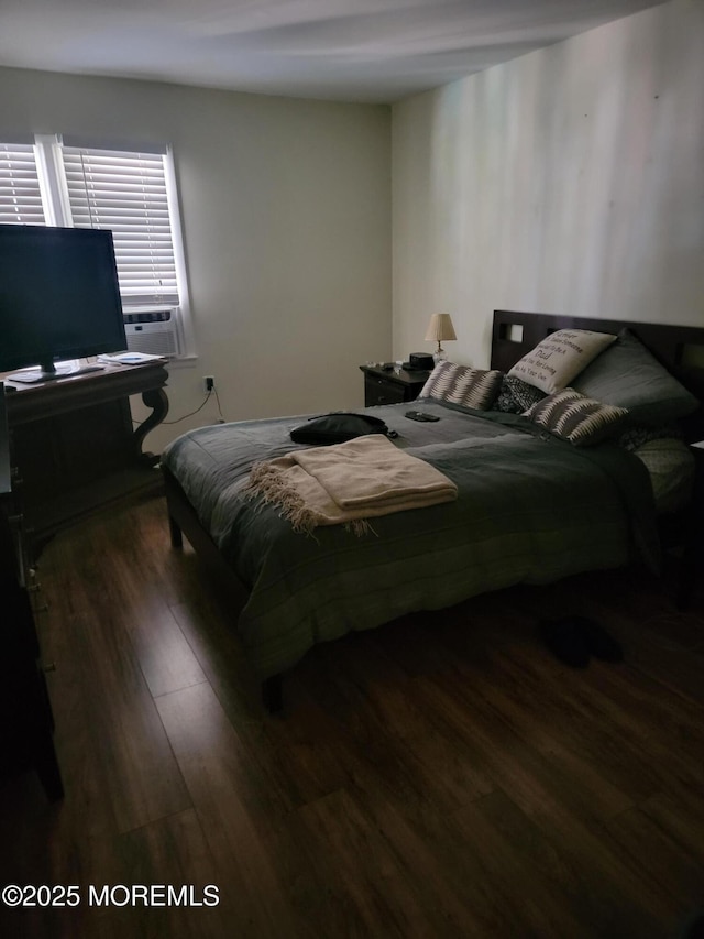 bedroom with cooling unit and wood finished floors