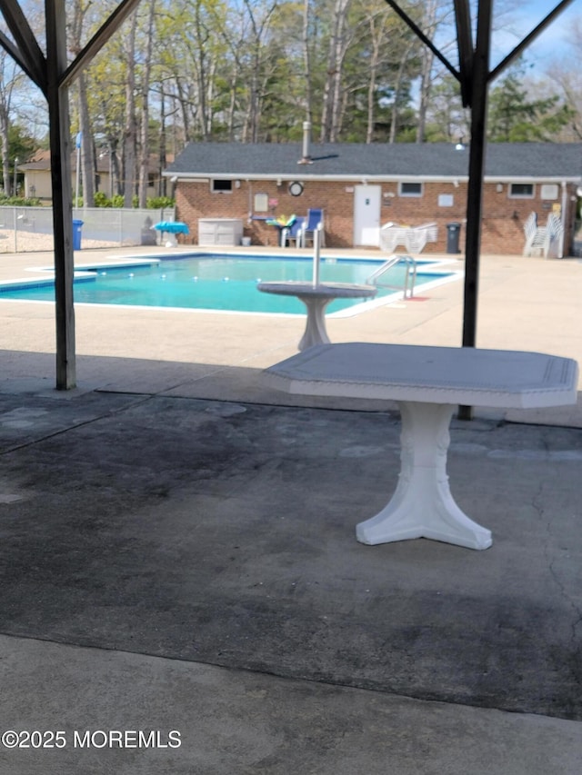 pool featuring an outdoor structure, a patio, and fence