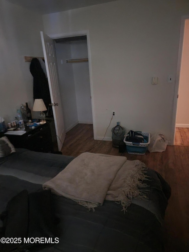 bedroom featuring baseboards, a closet, and wood finished floors