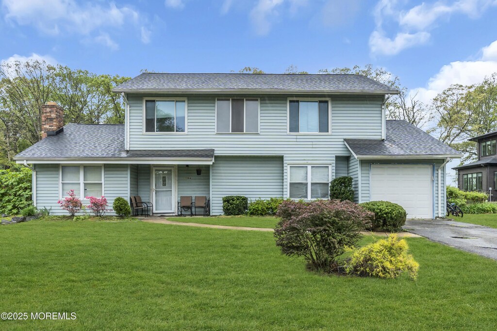 1584 Alamitos Dr, Lakewood, NJ 08701 - traditional home with a chimney, a shingled roof, aphalt driveway, and a front lawn