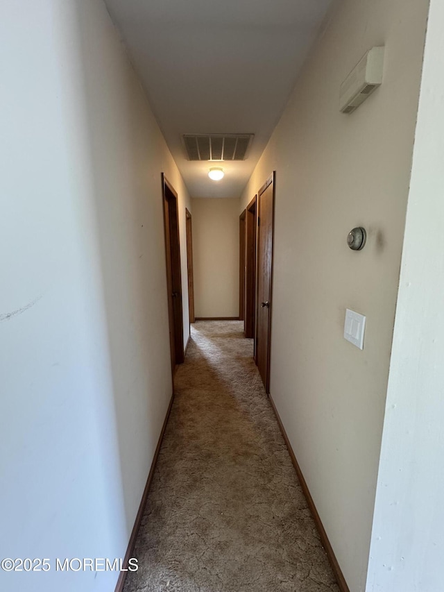 hallway with light carpet and visible vents