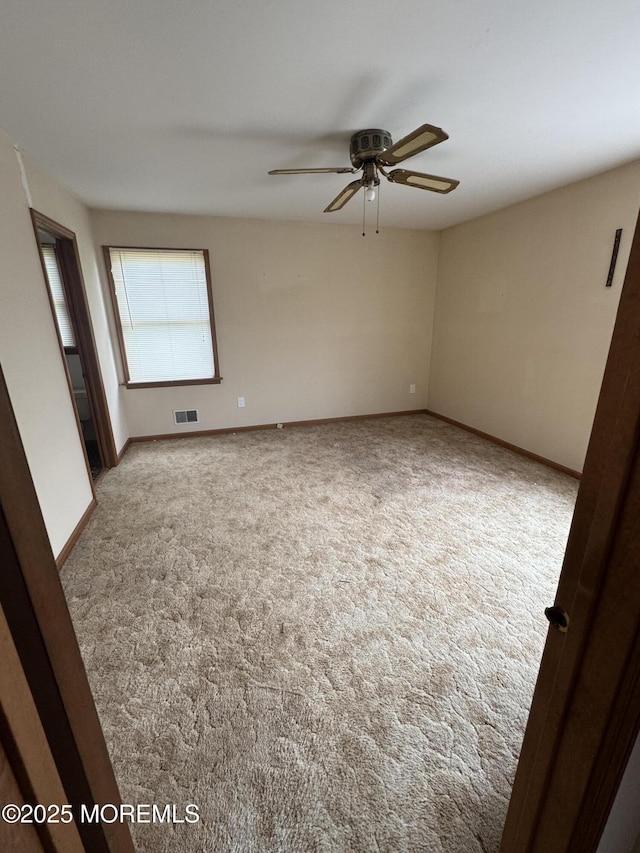 spare room featuring carpet, baseboards, and ceiling fan