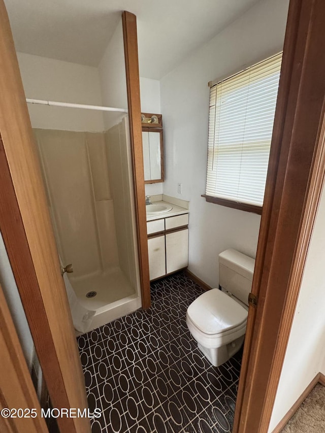 full bathroom with a shower stall, vanity, and toilet