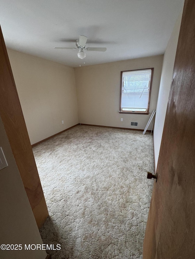 unfurnished room featuring baseboards, ceiling fan, carpet flooring, and visible vents