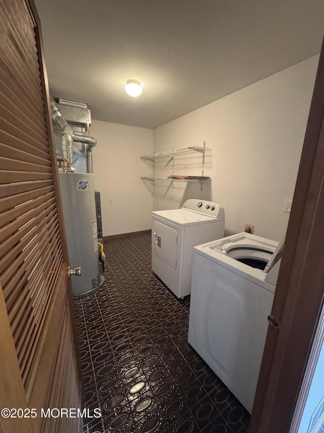 laundry area with laundry area, baseboards, separate washer and dryer, water heater, and dark floors