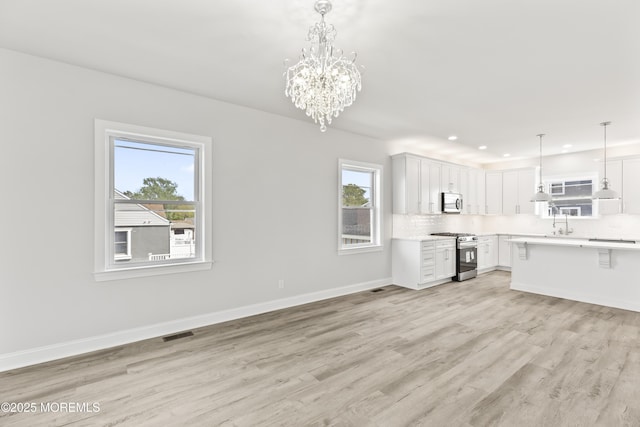 204 Morningside Ave, Union Beach, NJ 07735 - kitchen featuring stainless steel appliances, light countertops, light wood-style floors, tasteful backsplash, and white cabinetry