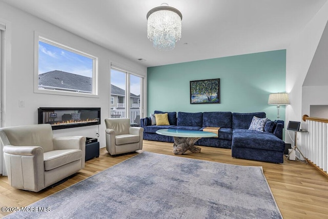 78 Ocean Ter, Long Branch, NJ 07740 - living room featuring wood finished floors, a chandelier, and a glass covered fireplace