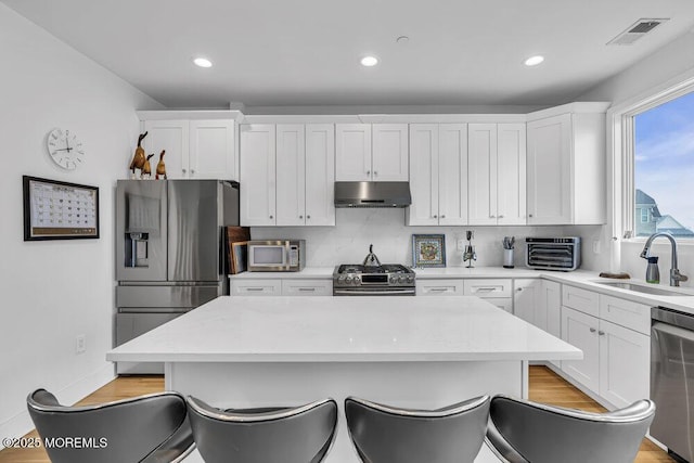 78 Ocean Ter, Long Branch, NJ 07740 - kitchen featuring appliances with stainless steel finishes, under cabinet range hood, a sink, white cabinetry, and recessed lighting
