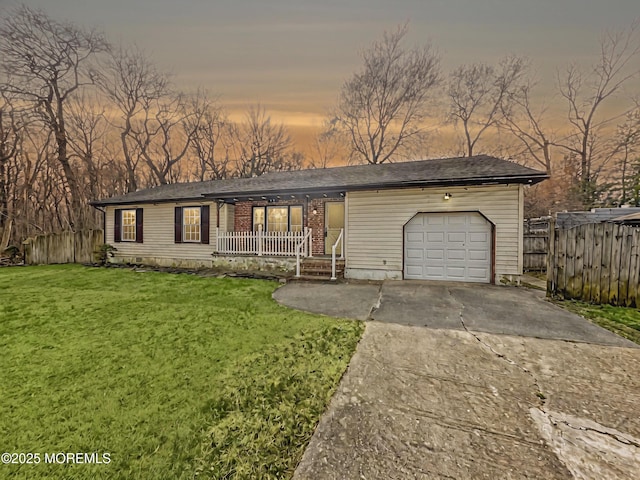 view of front facade featuring a yard, driveway, fence, covered porch, and an attached garage