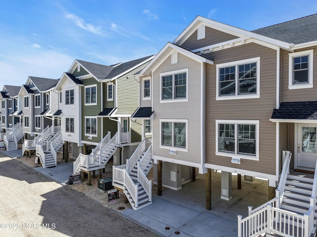 6 Shell Rd, Mantoloking, NJ 08738 - view of front facade with stairs, roof with shingles, and a residential view