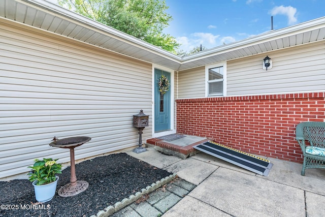 view of exterior entry featuring brick siding