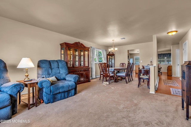 living room featuring a chandelier, light colored carpet, and a baseboard radiator
