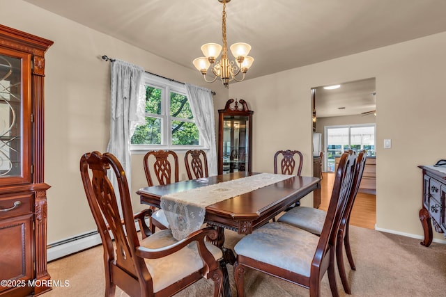 dining room with a chandelier, light carpet, a baseboard radiator, and baseboards