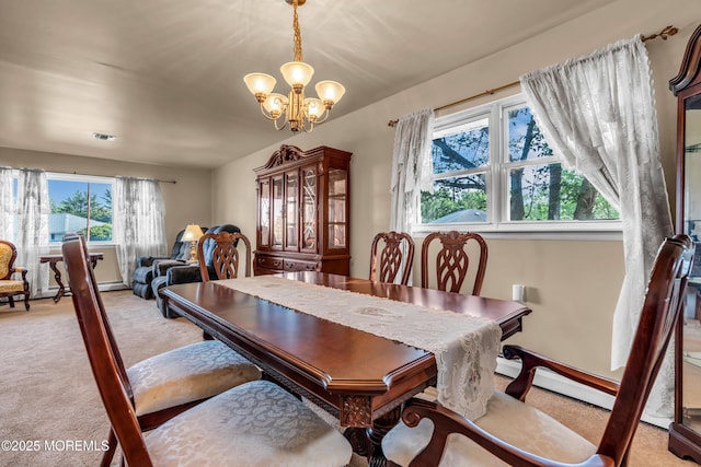 carpeted dining area with a chandelier